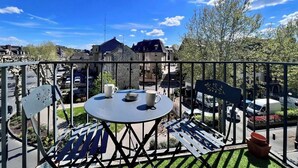 A balcony with a round table, two chairs, and a metal railing. - Casa #1407 - T2 - Climatisé avec Balcon - Centre-ville (Brive-la-Gaillarde)