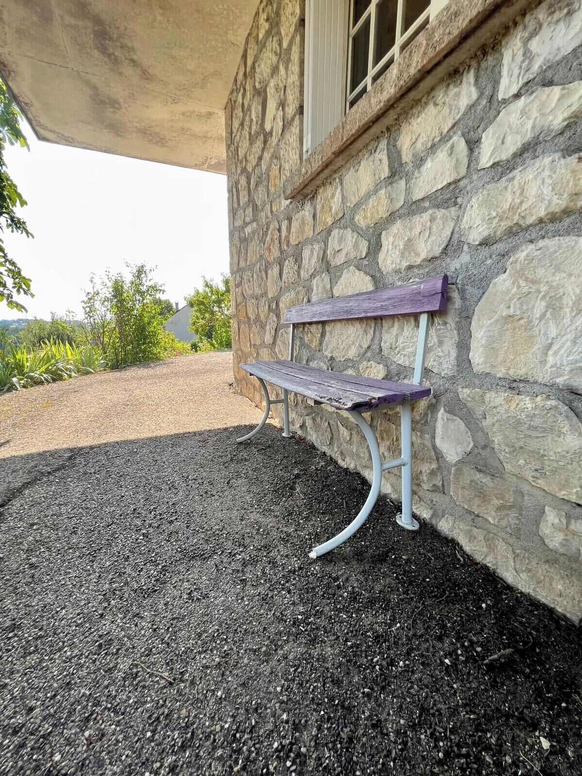A stone building with a bench outside.