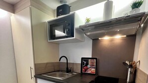 A modern kitchen with a microwave, stove, and sink. - Casa Cloutiers #1 -Studio RDC -Hyper Centre Brive (Brive-la-Gaillarde)