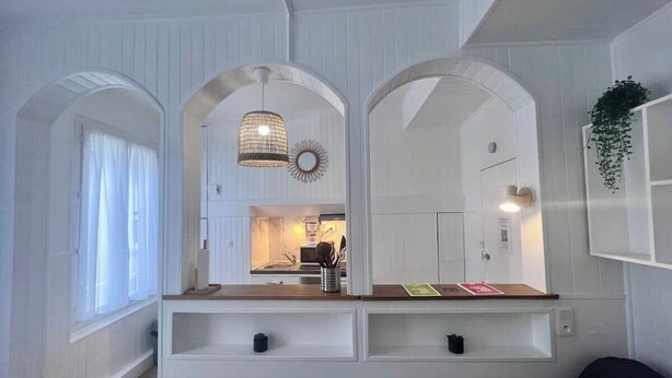 A modern kitchen with white cabinetry, a wooden countertop, and a hanging light fixture. - Casa Cloutiers #2 - Studio - Hyper Centre Brive (Brive-la-Gaillarde)