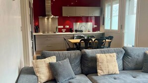 Ein modernes Wohnzimmer mit einem grauen Ecksofa und einem Couchtisch aus Holz.