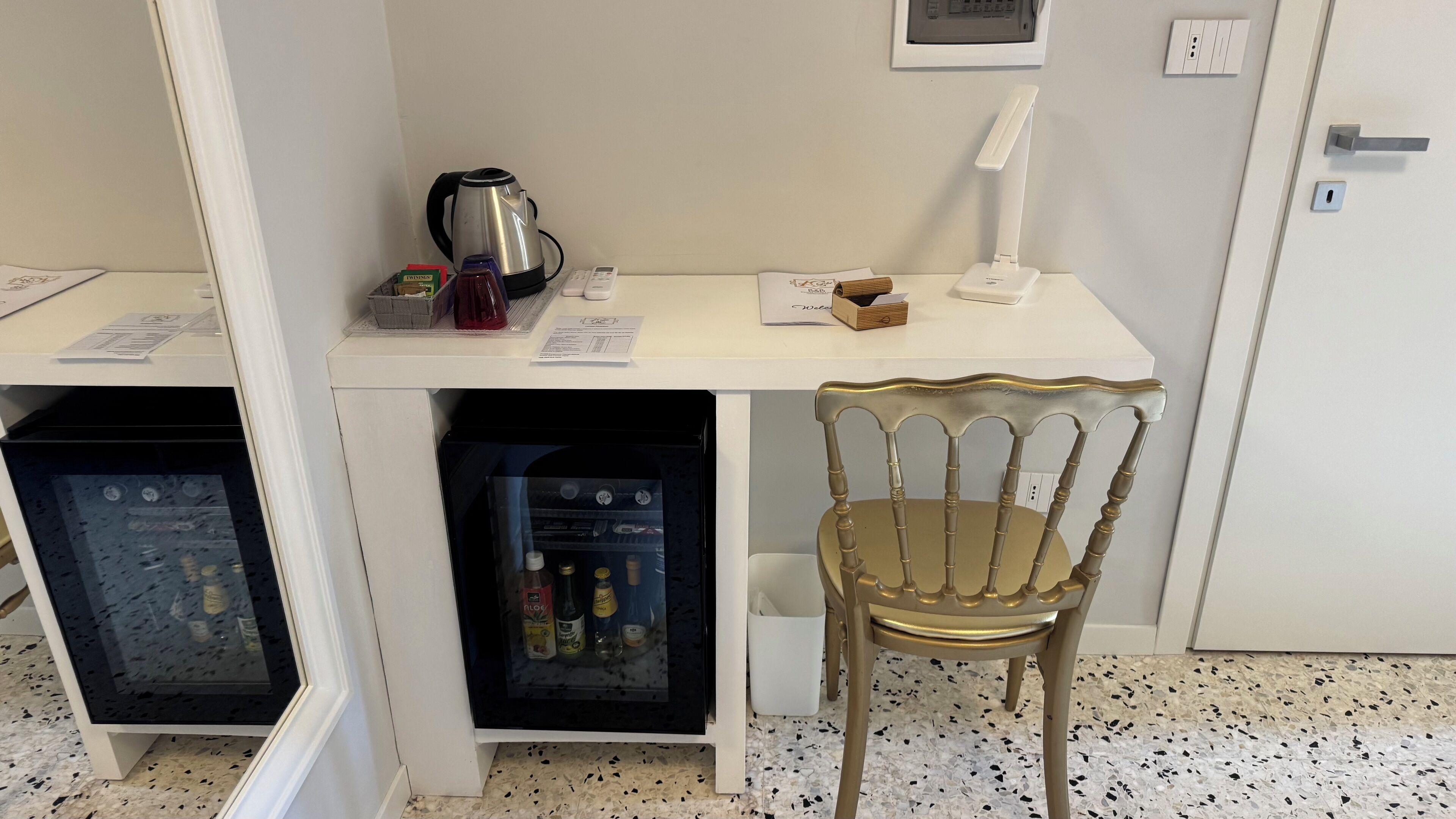Une petite cuisine équipée comprenant une machine à café, une petite table et une chaise.