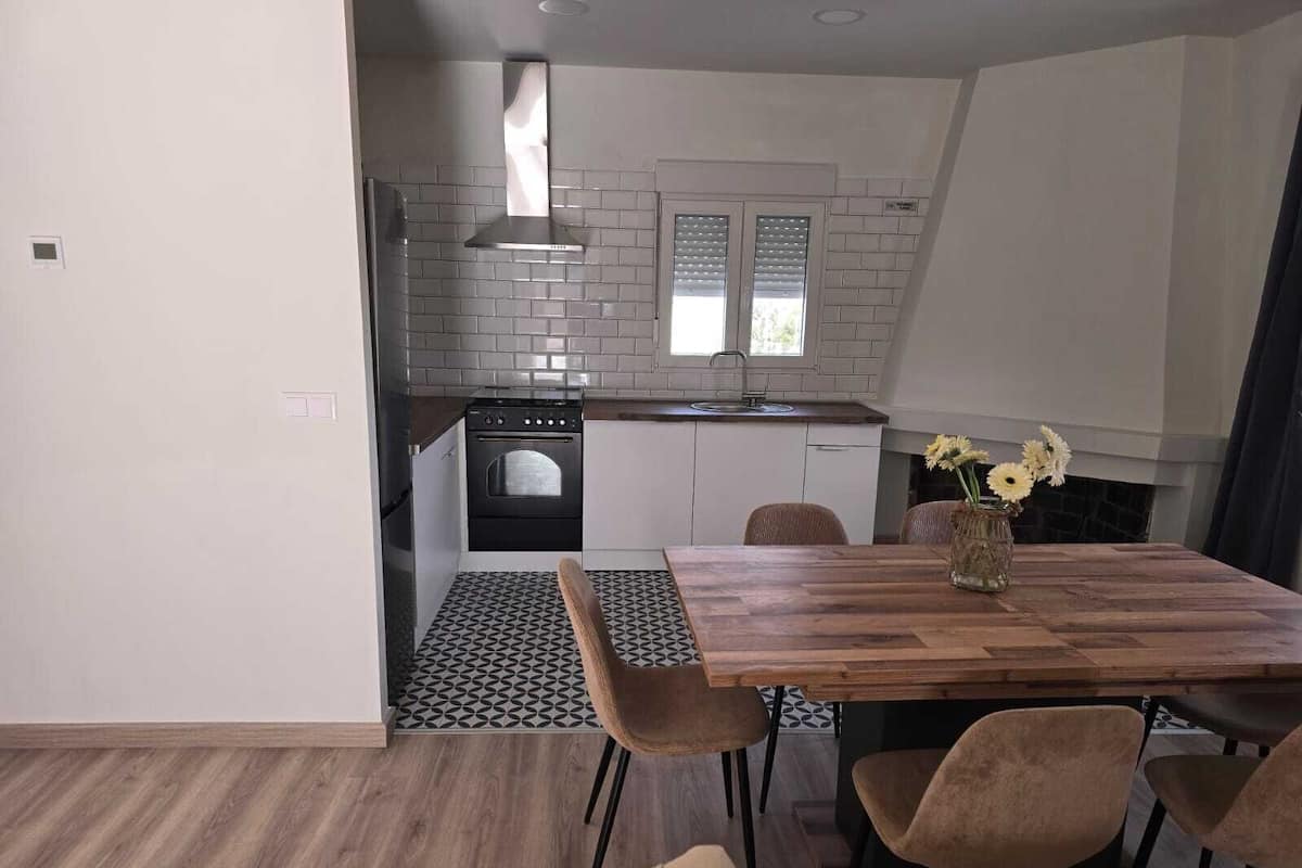 A compact kitchen with a modern stove, a built-in oven, and a small window.