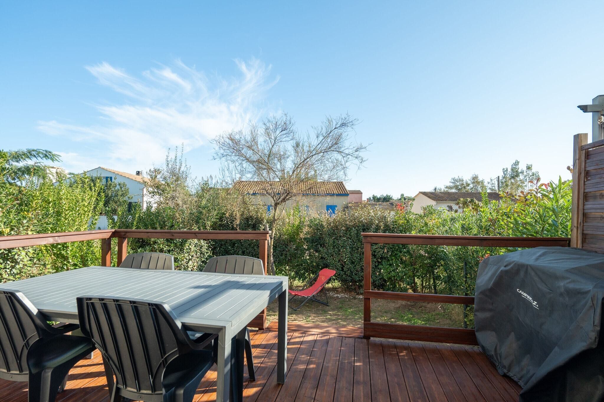 Une terrasse extérieure avec une table et des chaises, un barbecue et un espace salon abrité.