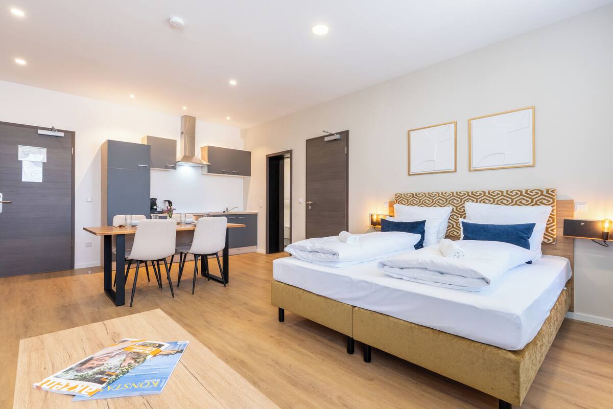 Een moderne hotelkamer met een bed, een bureau en een eethoek.