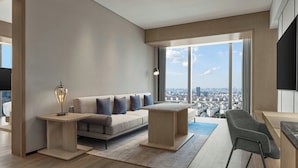 A modern living room with a sofa, coffee table, and a chair. It features large windows with a city view. - AC Hotel by Marriott Suzhou Industrial Park (Suzhou)