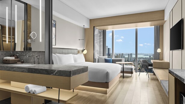 A modern hotel room with a large bed, a bathroom with a vanity, and a city view through large windows. - AC Hotel by Marriott Suzhou Industrial Park (Suzhou)