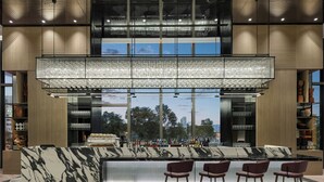 A modern bar area with a marble countertop, multiple seating options, and a large, illuminated chandelier. - AC Hotel by Marriott Suzhou Industrial Park (Suzhou)