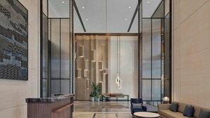 A modern lobby with a reception desk, seating area, and a large window providing natural light. - AC Hotel by Marriott Suzhou Industrial Park (Suzhou)