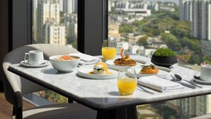A dining table with breakfast items and a city view. - AC Hotel by Marriott Suzhou Industrial Park (Suzhou)