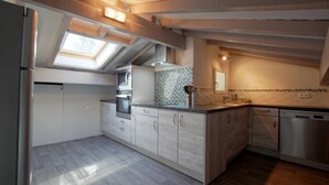 A modern kitchen with a skylight, built-in oven, and stainless steel appliances. - SEGURAKO BORDA - URRUGNE (URRUGNE)