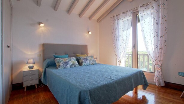 A bedroom with a bed, bedside tables, and a window with curtains. - SEGURAKO BORDA - URRUGNE (URRUGNE)