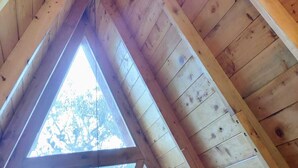 Un grenier en bois doté de lucarnes triangulaires et d’un plafond en pente.