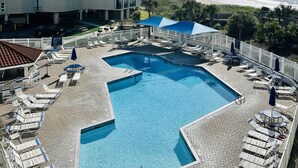A hotel with a swimming pool, lounge chairs, and a view of the ocean. - Captain's Retreat-St. Regis Condo #2104 (North Topsail Beach)