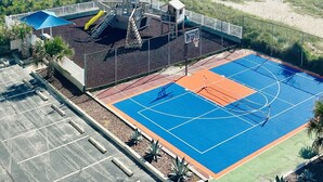 A beachside playground with a basketball court, a slide, and a small building structure. - Captain's Retreat-St. Regis Condo #2104 (North Topsail Beach)