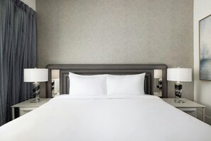 A hotel room with a large bed, two bedside tables, and a headboard. - Villatel Resort Orlando, Apartments by Marriott Bonvoy (Orlando)