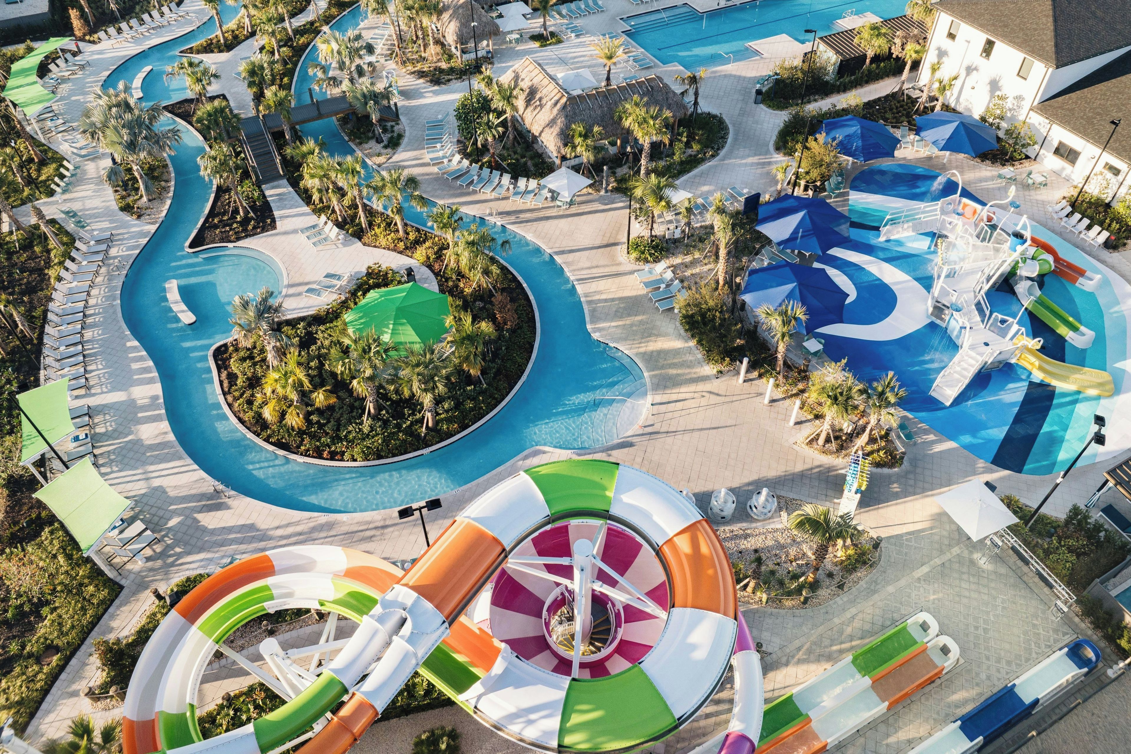 Une grande piscine extérieure dotée de plusieurs couloirs de nage et d’un toboggan.