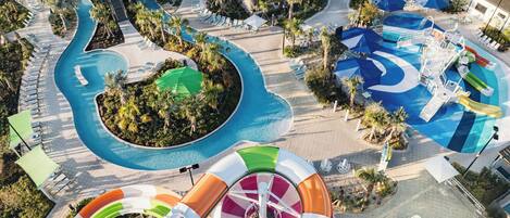Une grande piscine extérieure dotée de plusieurs couloirs de nage et d’un toboggan.