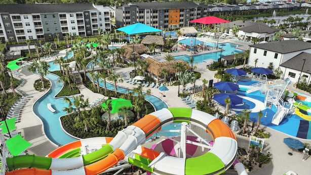 Un resort con varias piscinas, un tobogán de agua y una variedad de sombrillas.