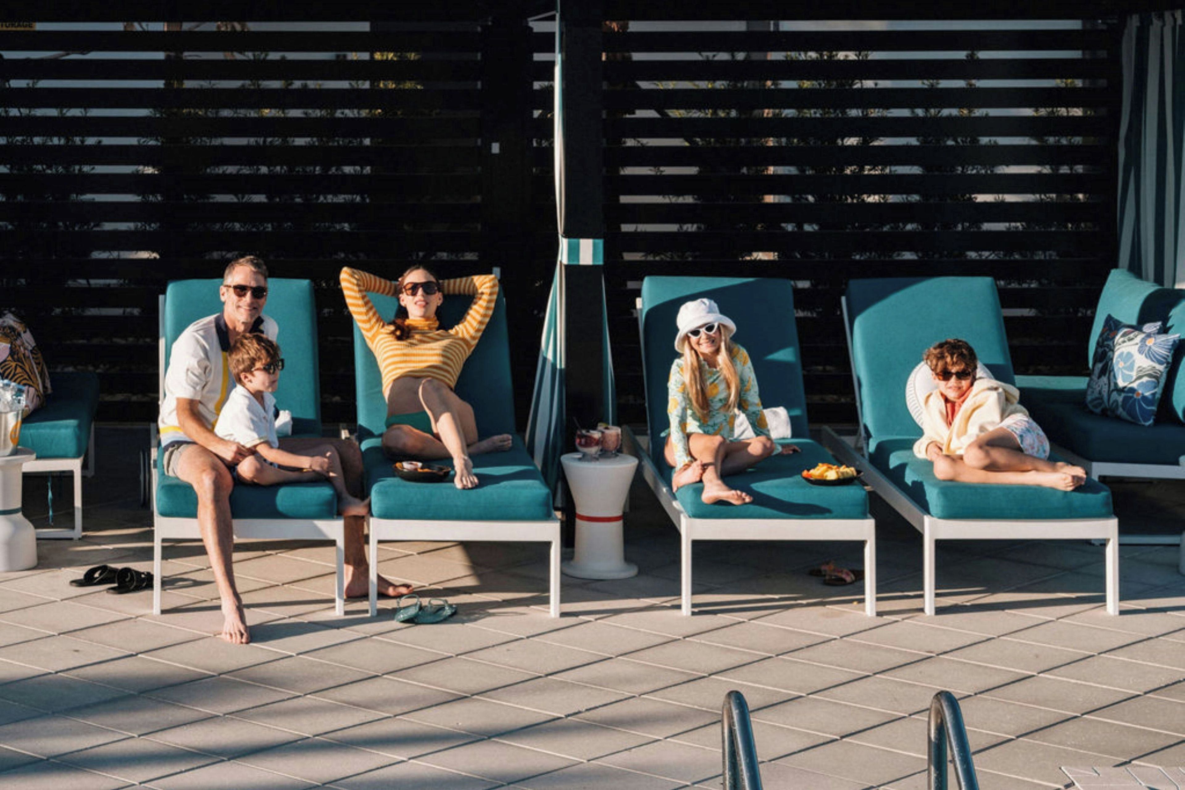 A poolside area with lounge chairs and a tiled floor.