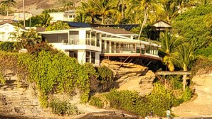 A coastal property with a modern house, lush greenery, and a rocky shoreline. - Glam Mid Century Modern 4-bedroom oceanfront estate in wonderful Honolulu (Honolulu)