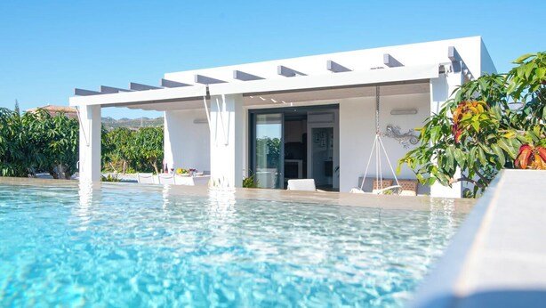 A modern poolside area with a covered seating area, clear blue pool water, and lush greenery. - Villa El Rincón de Lupe Torrox by Ruralidays (Málaga)