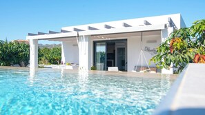 A modern poolside area with a covered seating area, clear blue pool water, and lush greenery. - Villa El Rincón de Lupe Torrox by Ruralidays (Málaga)