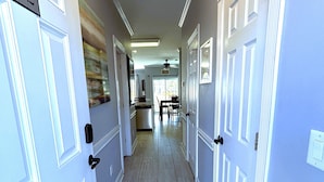 A hallway with white doors, each marked with a number. - First Floor Updated Coastal Summer Retreat at Magnolia Place - Pool View (Myrtle Beach)