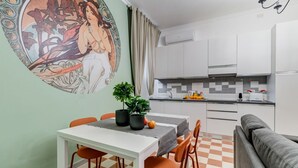 Comedor con una mesa, sillas y un mural en la pared.