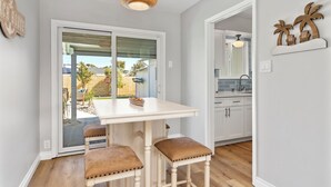 A kitchen with white cabinets, a white countertop, and a hanging light fixture. - Coastal Vibes Beach House (Oceanside)