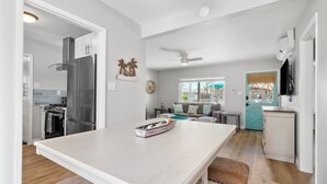 A modern kitchen with a large island, stainless steel appliances, and a view to the living area. - Coastal Vibes Beach House (Oceanside)