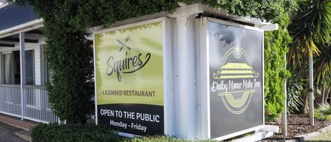 A sign for a licensed restaurant named 'Squires' open to the public from Monday to Friday.
