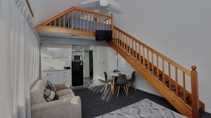 A modern apartment with a loft bedroom, a dining area, and a kitchen. - Dalby Manor Motor Inn  (Dalby)