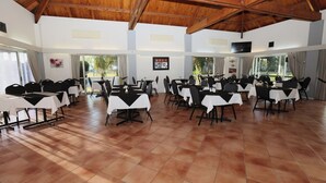 A spacious indoor dining area with multiple tables and chairs, large windows, and a wooden ceiling. - Dalby Manor Motor Inn  (Dalby)