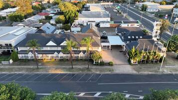 A commercial building with multiple units, a parking lot, and a street view.