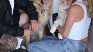 A family with a dog and a surfboard in a room with a tiled floor. - West Coast Surf and Stay (San Clemente)