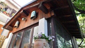Ein Gebäude mit Holzbalken, einem großen Fenster und einem Blumentopf mit Blumen.
