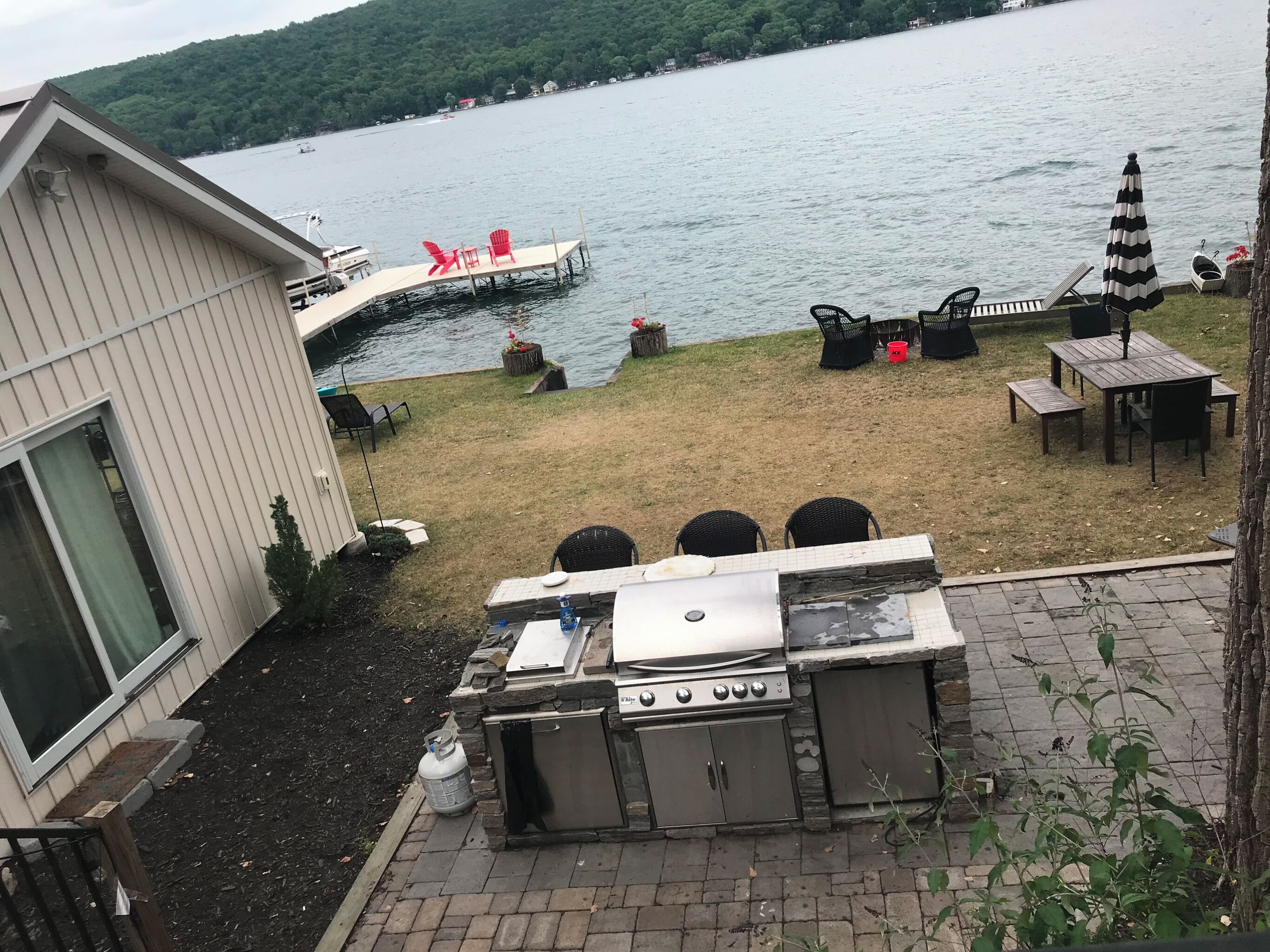 Una proprietà sul lago con patio, barbecue e zona salotto.