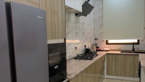 A modern kitchen with a stainless steel refrigerator, a built-in oven, and a gas stove. - Spacious 2-bedroom apartment (Lekki)