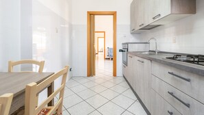 Una cocina moderna con una mesa de comedor y sillas, una estufa y armarios.