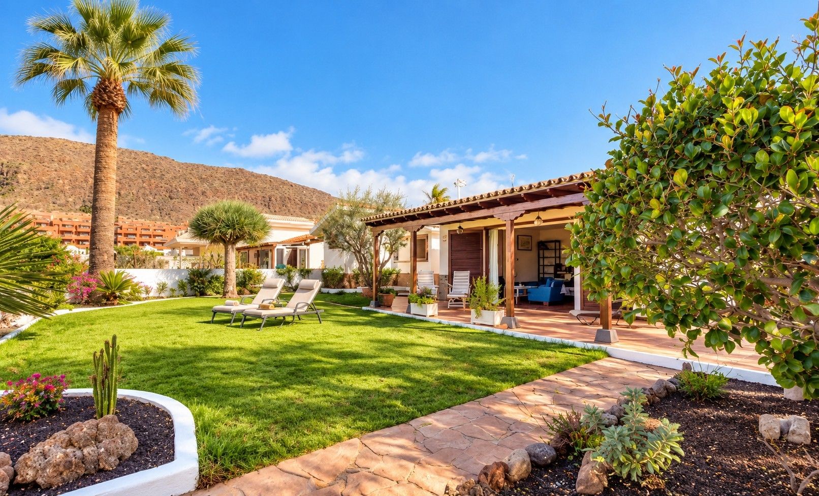 Propiedad residencial con patio, mobiliario exterior y césped bien cuidado.