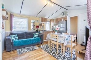 Un espace de vie compact comprenant un canapé, une table à manger et une kitchenette.