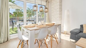 Un comedor moderno con una mesa, sillas y lámparas colgantes.