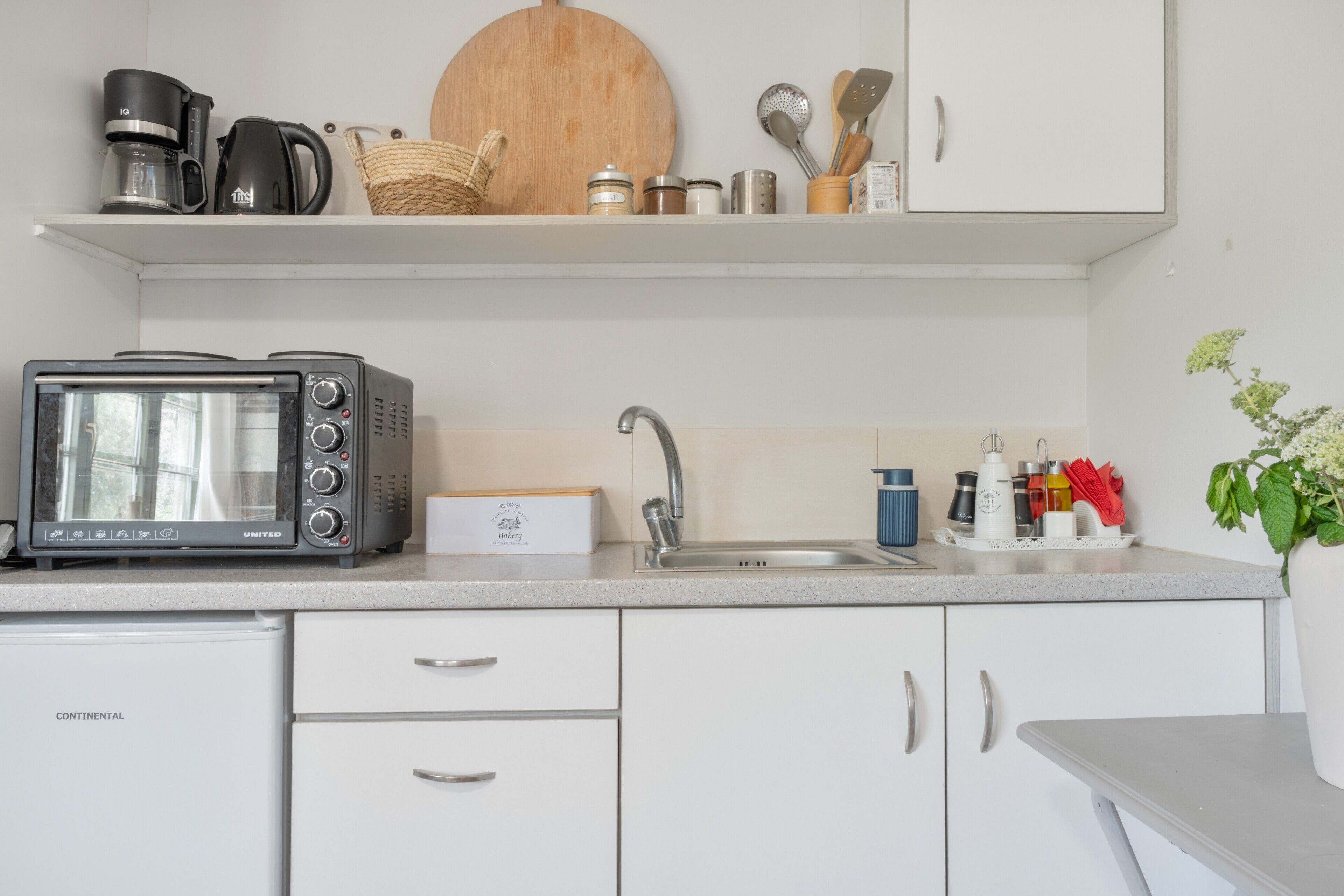 Une petite cuisine équipée d’un grille-pain, d’une machine à café et d’un évier.