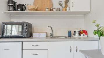 Une petite cuisine équipée d’un grille-pain, d’une machine à café et d’un évier.