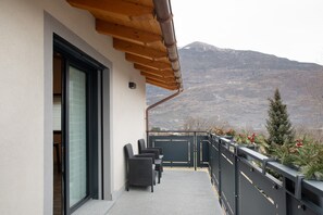 A balcony with a view of a mountain, a wooden pergola, and a railing with greenery. - Apartment 'Alice' with Mountain View, Wi-Fi and Air Conditioning (Caiolo)