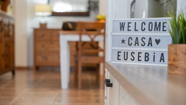 A sign with 'WELCOME' and 'CASA' on it, placed in a hallway with a wooden floor and furniture. - Holiday Apartment 'Casa Eusebia' with Wi-Fi (Arona)