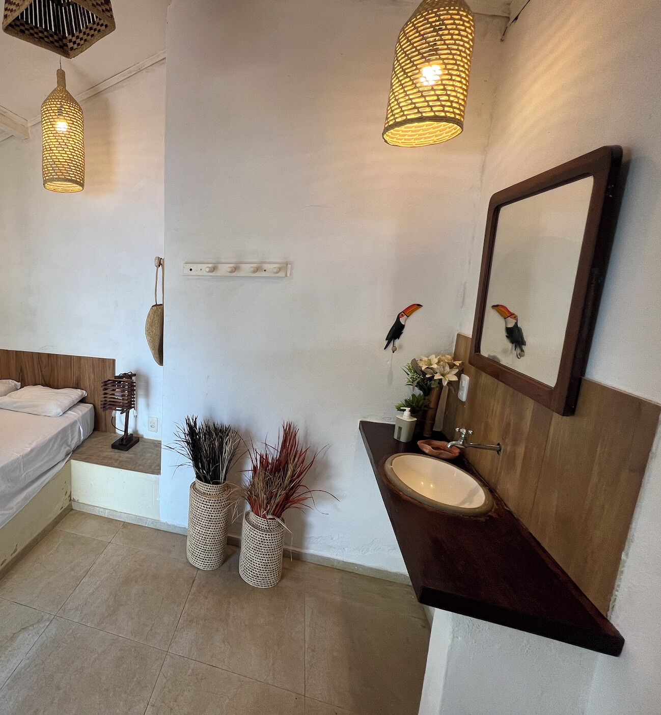 Une salle de bain moderne avec un meuble-lavabo en bois, un grand miroir et deux lampes suspendues.