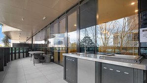 Ein moderner Außenbereich mit Tresen, Stühlen und Blick auf die Stadt.
