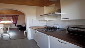 Una cocina moderna con armarios blancos, encimera de madera y estufa integrada.